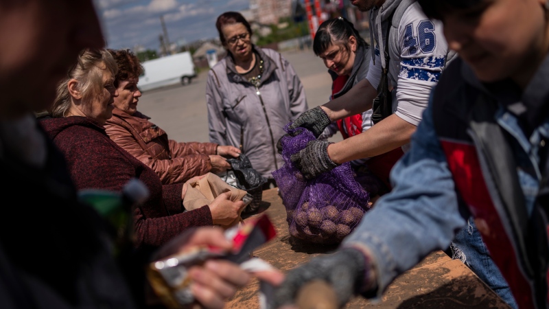 People receive food donations in Kharkiv, eastern Ukraine, Thursday, May 19, 2022. (AP Photo/Bernat Armangue)