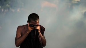 A Buddhist monk who is a member of the Inter University Students Federation covers his eyes after police fired tear gas during an anti government protest in Colombo, Sri Lanka, on May 19, 2022. (Eranga Jayawardena / AP) 