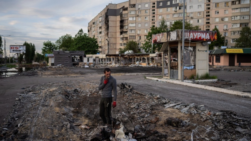 A man searches for metal scraps in a shelled neighbourhood in Kharkiv, eastern Ukraine, on May 19, 2022. (Bernat Armangue / AP) 