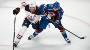 Edmonton Oilers defenseman Darnell Nurse, left, tangles with Colorado Avalanche left wing Andre Burakovsky in the first period of an NHL hockey game Monday, March 21, 2022, in Denver. (AP Photo/David Zalubowski)