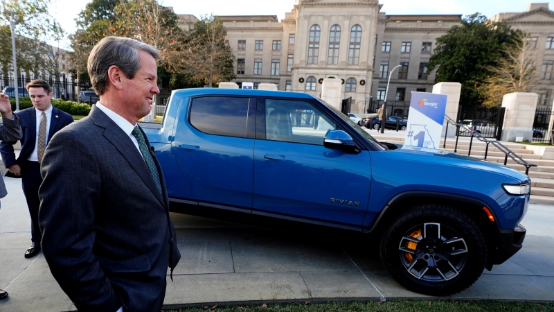 Gov. Brian Kemp stands next to a Rivian electric truck while announcing the company's plans to build a $5 billion plant east of Atlanta projected to employ 7,500 workers, Thursday, Dec. 16, 2021, in Atlanta. (AP Photo/John Bazemore, File)