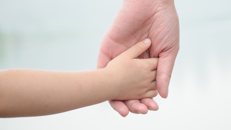 A father and son hold hands in an undated file image from Shutterstock. 