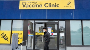 A staff member at a vaccine clinic looks outside the clinic for people waiting to get their COVID-19 vaccine or flu shot during the COVID-19 pandemic, in Mississauga, Ont., on Wednesday, April 13, 2022. THE CANADIAN PRESS/Nathan Denette
