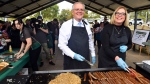 Australia's Prime Minister Scott Morrison, centre, works at a barbecue, colloquially known as a sausage sizzle, along with Liberal candidate for Pearce Linda Aitken while electioneering in Perth, Friday, May 20, 2022. (Mick Tsikas/AAP Image via AP) 