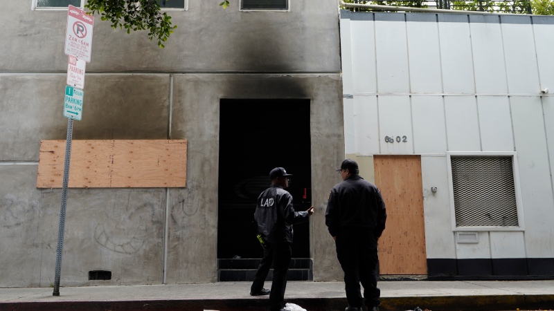 Los Angeles Fire City investigators check the smoked exterior of a Hollywood recording studio in Los Angeles Friday, May 20, 2022. Ozzy Osbourne's daughter Aimee and her producer escaped a Hollywood recording studio fire that killed another person, her mother said.(AP Photo/Damian Dovarganes)