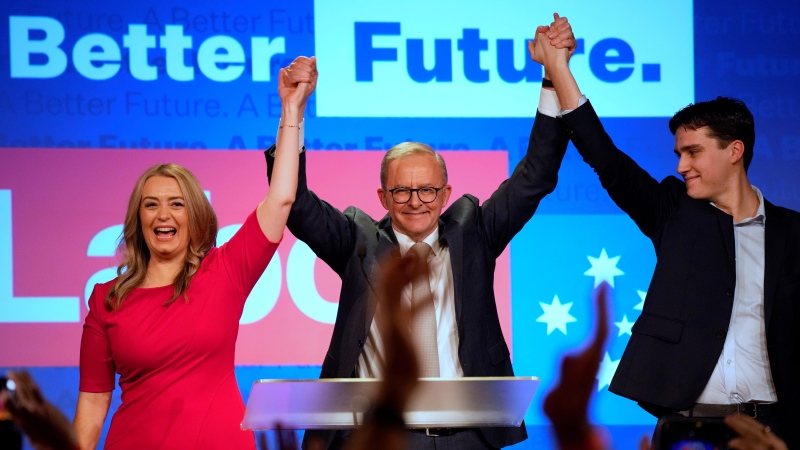 Labor Party leader Anthony Albanese, center, celebrates with his son Nathan, right, and his partner Jodie Haydon at a Labor Party event in Sydney, Australia. (AP Photo/Rick Rycroft)