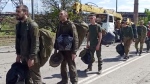 In this photo taken from video released by the Russian Defense Ministry on Friday, May 20, 2022, Ukrainian servicemen are pictured as they leave the besieged Azovstal steel plant in Mariupol, in territory under the government of the Donetsk People's Republic, eastern Ukraine. (Russian Defense Ministry Press Service via AP)

