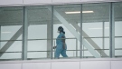 A health-care worker walks across a footbridge in a hospital in Montreal in this file photo dated Sunday, Jan. 9, 2022. THE CANADIAN PRESS/Graham Hughes