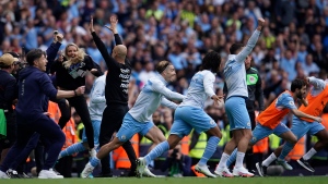 Manchester City's head coach Pep Guardiola and his teammates celebrate after winning the English Premier League soccer match between Manchester City and Aston Villa at the Etihad Stadium in Manchester, England, Sunday, May 22, 2022. (AP Photo/Dave Thompson)