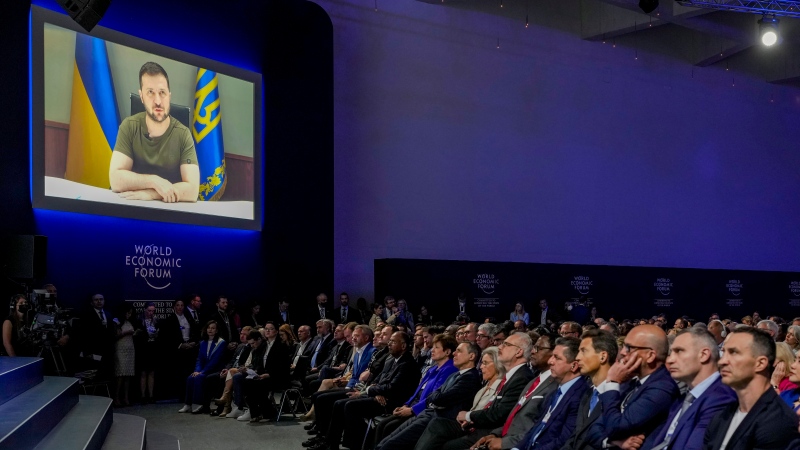Ukrainian President Volodymyr Zelenskyy displayed on a screen as he addresses the audience from Kyiv on a screen during the World Economic Forum in Davos, Switzerland, Monday, May 23, 2022. (AP Photo/Markus Schreiber)