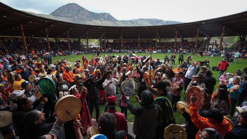 Drummers play and sing during a ceremony to mark the one-year anniversary of the announcement of the detection of the remains of children at an unmarked burial site at the former Kamloops Indian Residential School, in Kamloops, B.C., on Monday, May 23, 2022. THE CANADIAN PRESS/Darryl Dyck 