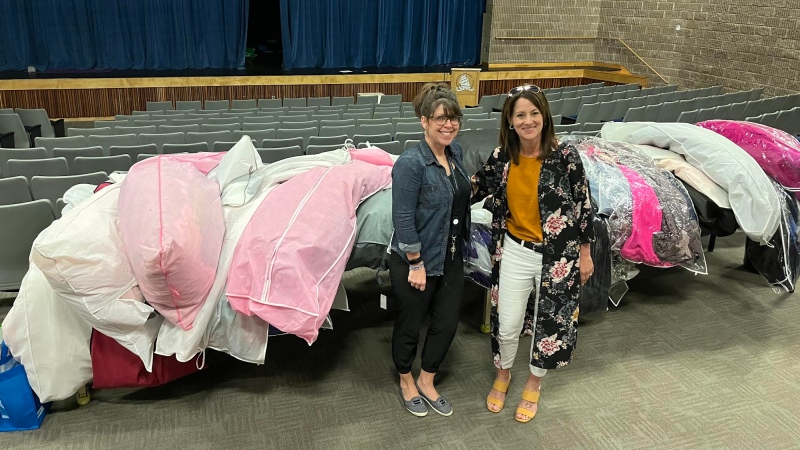 Lori Pellerin and Cheryl DesRoches stand in front of some of the donated prom dresses at Fundy High School in St. George, N.B. on May 23, 2022. (Photo submitted)