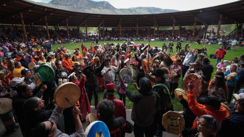 Drummers play and sing during a ceremony to mark the one-year anniversary of the TkÕemlœps te SecwŽpemc announcement of the detection of the remains of 215 children at an unmarked burial site at the former Kamloops Indian Residential School, in Kamloops, B.C., on Monday, May 23, 2022. THE CANADIAN PRESS/Darryl Dyck