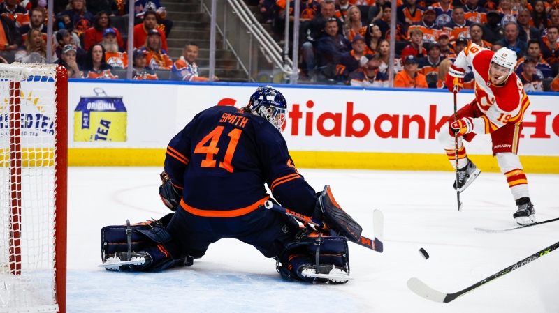 Calgary Flames forward Matthew Tkachuk, right, looks on as Edmonton Oilers goalie Mike Smith deflects his shot during first period NHL second round playoff hockey action in Edmonton, Sunday, May 22, 2022. THE CANADIAN PRESS/Jeff McIntosh