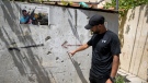Palestinian Salim Wad points out bullets holes left from a gunbattle between Palestinian militants and Israeli soldiers in a set of narrow alleys some 300 metres from where veteran Palestinian-American Al-Jazeera journalist Shireen Abu Akleh was shot and killed, in the West Bank city of Jenin, on May 19, 2022. (Majdi Mohammed / AP)