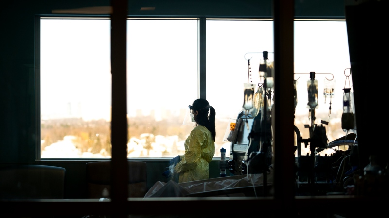 A registered nurse takes a moment to look outside while attending to a ventilated COVID-19 patient in the intensive care unit at the Humber River Hospital during the COVID-19 pandemic in Toronto on Tuesday, January 25, 2022. THE CANADIAN PRESS/Nathan Denette