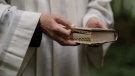 A pastor is seen holding the Bible in this stock photo. (Pexels)