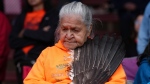 Kamloops Indian Residential School survivor Evelyn Camille holds eagle feathers as she laughs during a ceremony to mark the one-year anniversary of the announcement of the detection of the remains of 215 children at an unmarked burial site at the former residential school, in Kamloops, B.C., on Monday, May 23, 2022. THE CANADIAN PRESS/Darryl Dyck 