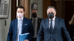 FILE: Quebec Premier Francois Legault, right, and Quebec Justice Minister Simon Jolin-Barrette, responsible for language law, walk to a news conference after tabling a reform on language law, Thursday, May 13, 2021 at the legislature in Quebec City. THE CANADIAN PRESS/Jacques Boissinot