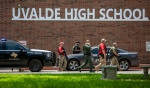 Law enforcement personnel walk outside Uvalde High School after shooting a was reported earlier in the day at Robb Elementary School, Tuesday, May 24, 2022, in Uvalde, Texas. (William Luther/The San Antonio Express-News via AP)