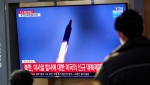 People watch a TV screen showing a news program reporting about North Korea's missile launch with a file image, at a train station in Seoul, South Korea, Friday, Jan. 14, 2022. (AP Photo/Lee Jin-man)