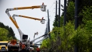 Utility workers use bucket lifts to repair lines along Hawthorne Road after Saturday’s major storm caused significant damage to the city’s power distribution network, in Ottawa, on Tuesday, May 24, 2022. (Justin Tang/THE CANADIAN PRESS)
