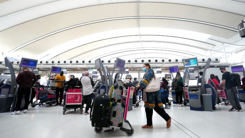 People wait in line to check in at Pearson International Airport in Toronto on May 12, 2022. THE CANADIAN PRESS/Nathan Denette