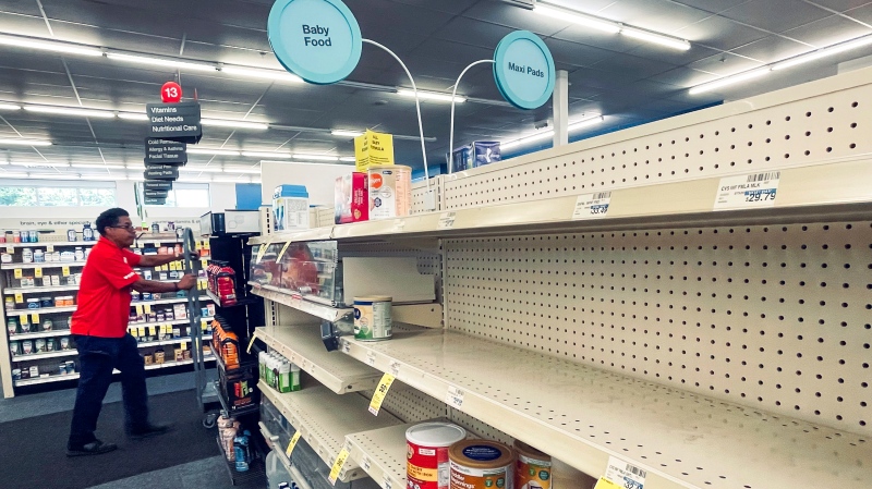 An employee walks near empty shelves where baby formula would normally be located at a CVS in New Orleans on Monday, May 16, 2022. (Chris Granger/The Times-Picayune/The New Orleans Advocate via AP)