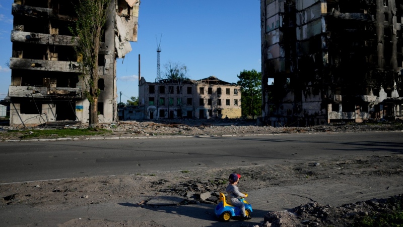 A boy plays in front of houses ruined by shelling in Borodyanka, Ukraine, on May 24, 2022. (Natacha Pisarenko /AP) 