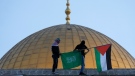 Masked Palestinians carry Palestinian and Hamas flags during Eid al-Fitr celebrations next to the next to the Dome of the Rock Mosque in the Al-Aqsa Mosque compound in the Old City of Jerusalem on May 2, 2022. Israeli authorities said on May 24 they have foiled a wide-ranging plot by Hamas militants to shoot a member of parliament, kidnap soldiers and bomb Jerusalem's light rail system during a surge of violence that has left dozens dead in recent weeks. (AP Photo/Mahmoud Illean, File)