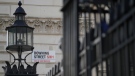 The Downing Street sign above the security gate entrance to the street in, London on May 12, 2022. London's Metropolitan Police force says the number of fines issued over breaches of coronavirus regulations at British government offices has expanded to more than 100. (AP Photo/Alastair Grant)
