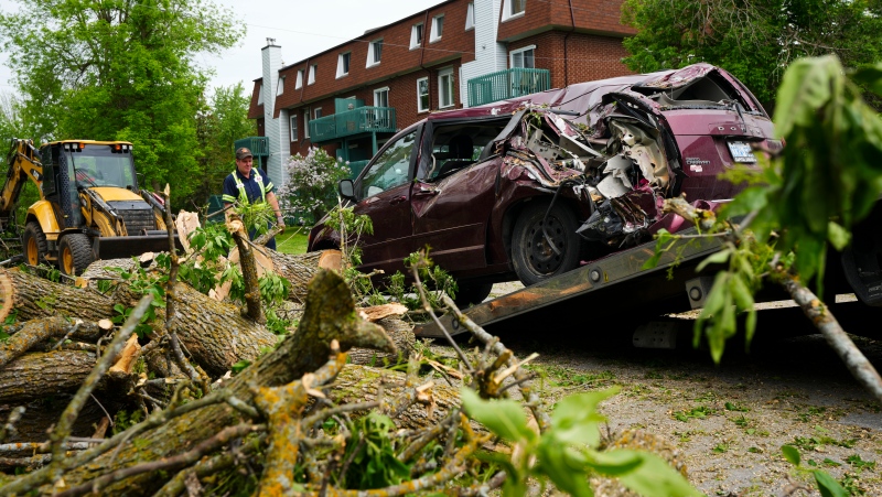 John from Costello's Towing hoists a vehicle that was crushed under tree in the Ottawa Valley community of Carleton Place, Ont. on Tuesday, May 24, 2022. The vehicle was trapped with it occupants under a tree in a major storm that hit parts of Ontario and Quebec on Saturday. THE CANADIAN PRESS/Sean Kilpatrick