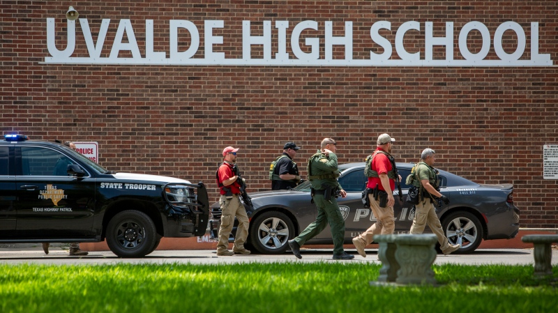 Law enforcement personnel walk outside Uvalde High School after shooting a was reported earlier in the day at Robb Elementary School on May 24, 2022, in Uvalde, Texas. (William Luther/The San Antonio Express-News via AP)