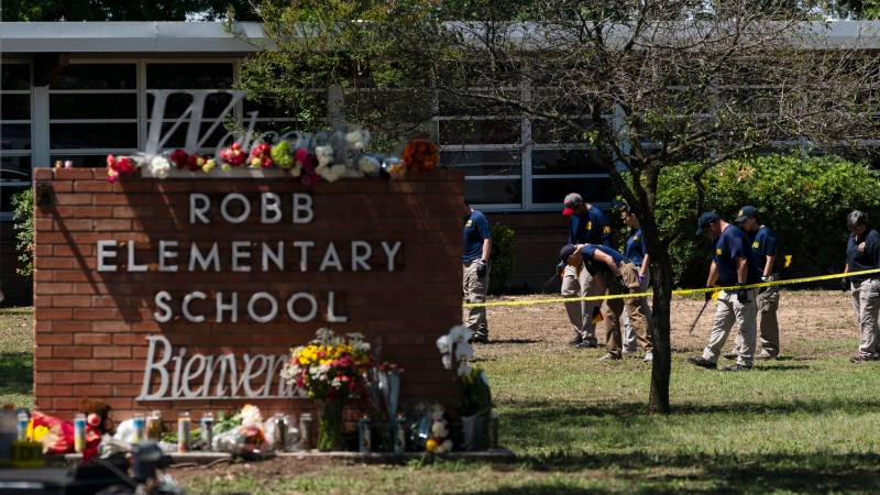 Flowers and candles are placed outside Robb Elementary School in Uvalde, Texas, Wednesday, May 25, 2022, to honor the victims killed in Tuesday's shooting at the school.  (AP Photo/Jae C. Hong)