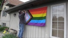 Jeff Ducharme replaces his stolen pride flag off the front of his Norwich, Ont. home on May 25, 2022. (Brent Lale/CTV News London)