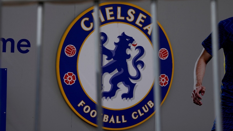 A Chelsea football club logo is displayed with a barrier in the foreground at an entrance to Chelsea's Stamford Bridge stadium in London, on April 18, 2022.  (Matt Dunham / AP) 