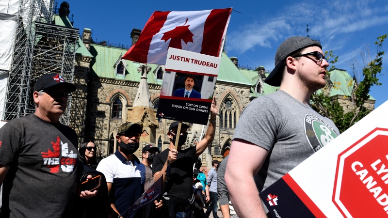 Gun owners hold signs criticizing Prime Minister Justin Trudeau as they participate in a rally organized by the Canadian Coalition for Firearm Rights against the government's new gun regulations, on Parliament Hill in Ottawa, on Saturday, Sept. 12, 2020. THE CANADIAN PRESS/Justin Tang