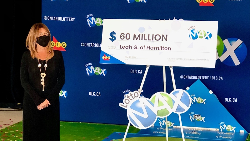 Leah Murdoch-Gerics stands next to a $60 million cheque after she won last month's OLG Lotto Max jackpot.