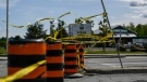 Police tape flutters in the breeze as a section of Hawthorne Road is closed as crews repair lines on the side of the road after Saturday’s major storm caused significant damage to the city’s power distribution network, in Ottawa, on Tuesday, May 24, 2022. (Justin Tang/THE CANADIAN PRESS)