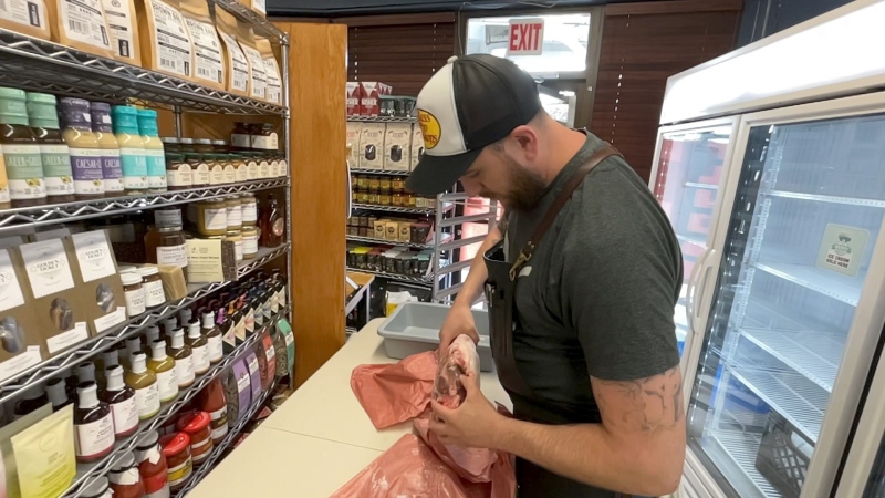 Around the Block Butcher Shop employee inspecting frozen meat. (Dave Charbonneau/CTV News Ottawa) 