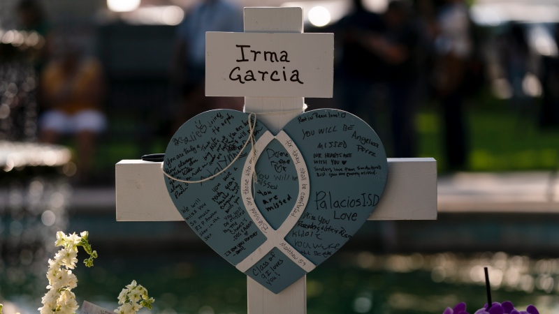 Messages are written on a cross honouring Irma Garcia, a teacher who was killed in this week's elementary school shooting, in Uvalde, Texas, Thursday, May 26, 2022. (AP Photo/Jae C. Hong)