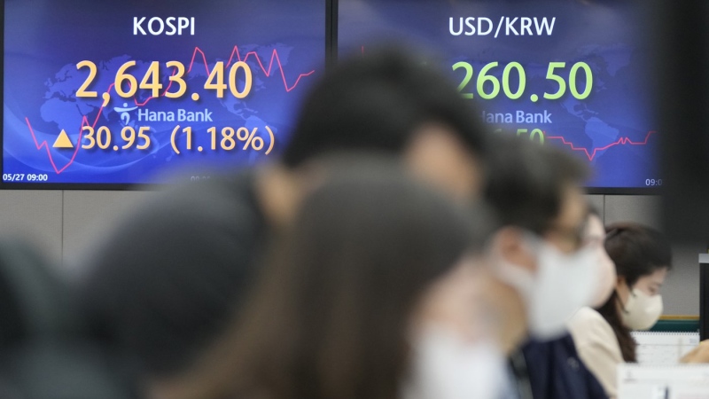 Currency traders watch computer monitors near the screens showing the Korea Composite Stock Price Index, left, and the foreign exchange rate between the U.S. dollar and South Korean won at a foreign exchange dealing room in Seoul, South Korea, May 27, 2022. (AP Photo/Lee Jin-man)