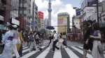 People walk along a pedestrian crossing in the tourist district of Asakusa, near the landmark Tokyo Skytree tower in Tokyo, Japan, July 31, 2021. (AP Photo/Kantaro Komiya]