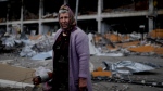 A woman stands in front of a damage building ruined by attacks in Irpin, outskirts Kyiv, Ukraine, May 26, 2022. (AP Photo/Natacha Pisarenko