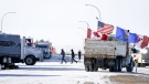 The last truck blocking the southbound lane moves off after a breakthrough to resolve the impasse at a protest blockade at the United States border in Coutts, Alta., Wednesday, Feb. 2, 2022. Trucks and other vehicles have begun clearing two lanes -- one going north and one going south. THE CANADIAN PRESS/Jeff McIntosh