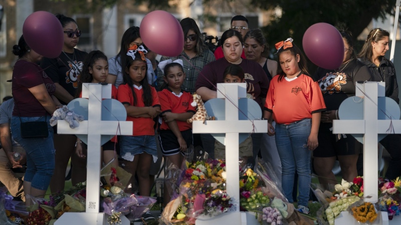 People gather at a memorial site to pay their respects to the victims killed in this week's elementary school shooting in Uvalde, Texas, May 26, 2022. (AP Photo/Jae C. Hong)
