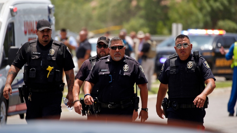 Police walk near Robb Elementary School following a shooting, Tuesday, May 24, 2022, in Uvalde, Texas. (AP Photo/Dario Lopez-Mills) 
