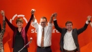 Gabriel Nadeau-Dubois, right, has his arms raised by Quebec Solidaire co-leader Andres Fontecilla, centre, and former co-leader Francoise David. THE CANADIAN PRESS/Graham Hughes
