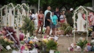 People visit a memorial outside Robb Elementary School in Uvalde, Texas, Monday, May 30, 2022. On May 24, 2022, an 18-year-old entered the school and fatally shot several children and teachers. (AP Photo/Wong Maye-E)