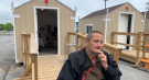 Barry Shea sits in front of his sleeping cabin, which has been built to help him while he waits for permanent housing in Kingston, Ont.. (Kimberley Johnson/CTV News Ottawa)
